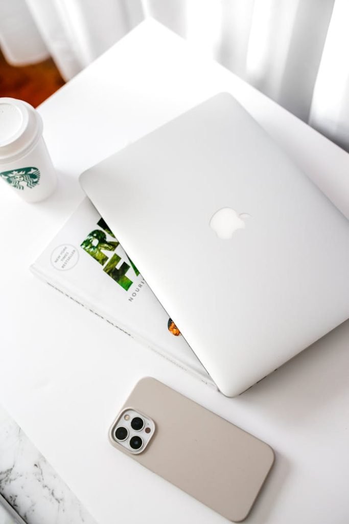 Stylish workspace featuring a laptop, smartphone, and coffee cup on a bright desk.
